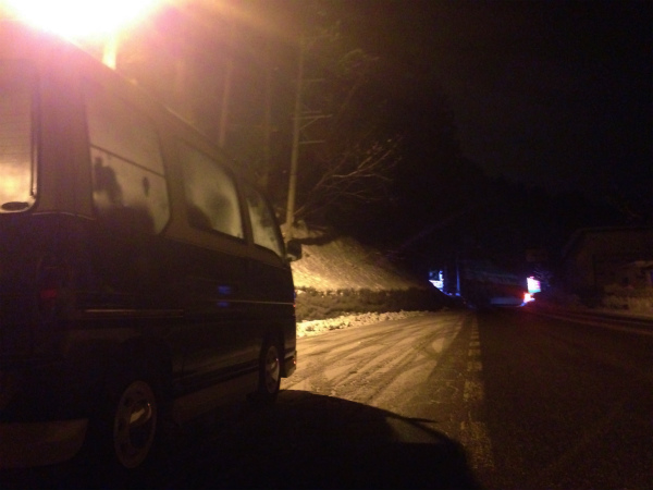 夜の雪道の中でエンジンを切ってじっと待つ